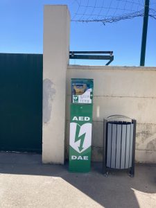 Défibrillateur installé dans un boîtier extérieur sur totem bornavie devant un mur